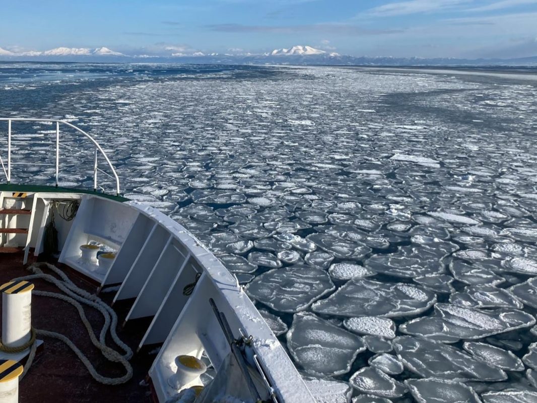 Vessel moving through broken ice on a frozen waterway during winter navigation conditions.