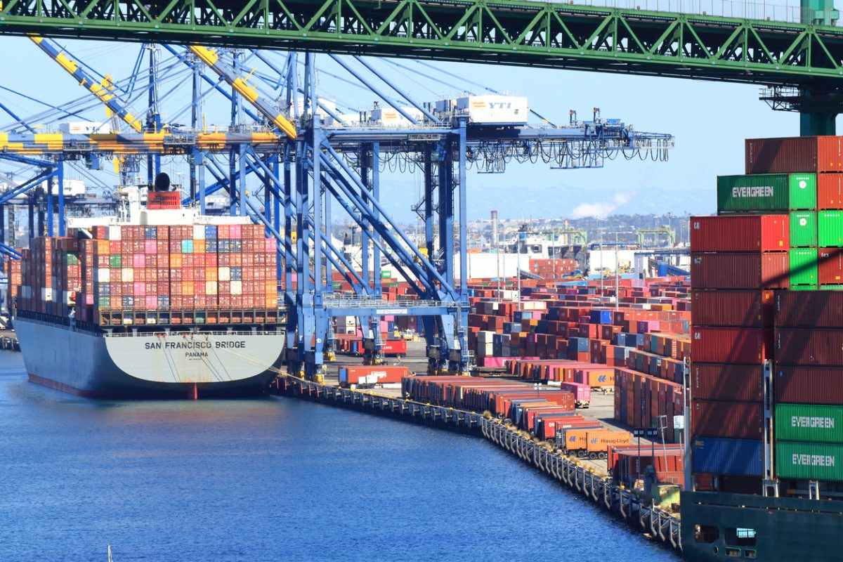 Busy container terminal at the Port of Los Angeles with cranes and containers.