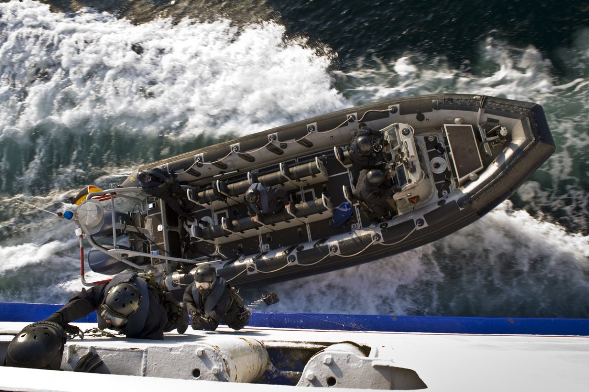 Naval boarding team approaches a vessel by RHIB during offshore maritime interdiction operation