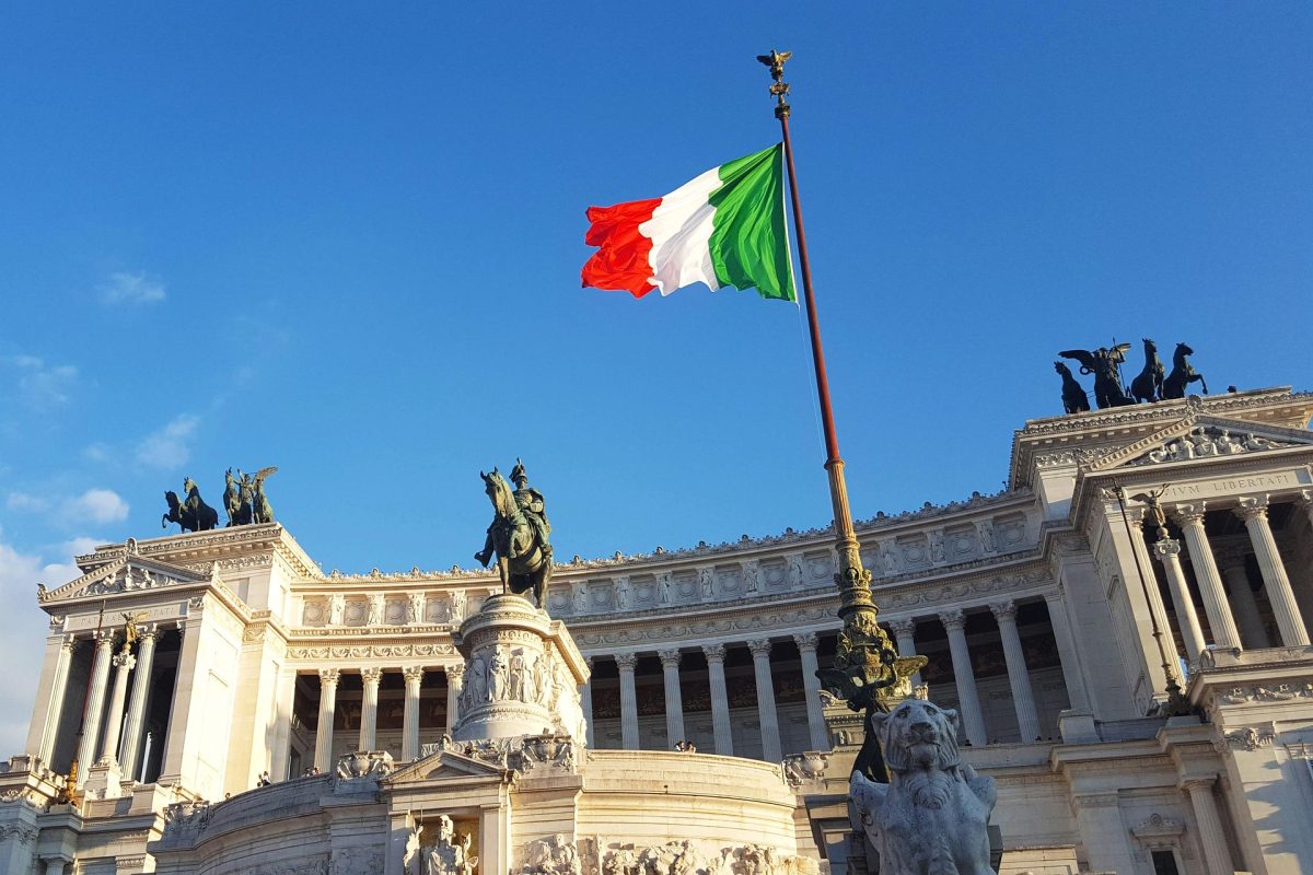 Italian flag above Rome representing Italy’s legislative action on emigrant boat policy