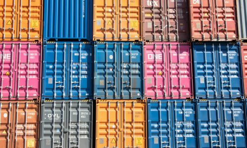 Stacks of multicolored shipping containers at a port