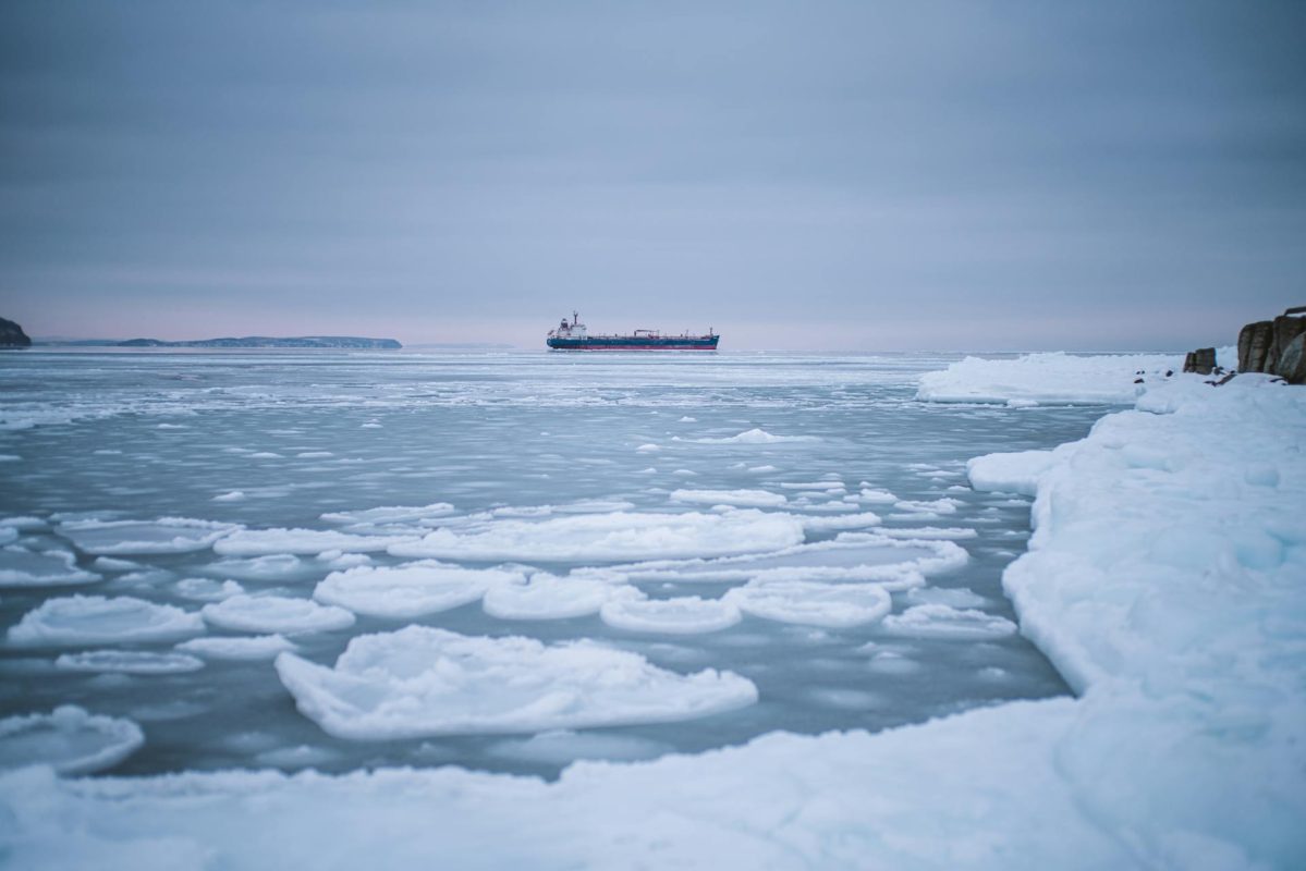 Melting Arctic iceberg and ice field representing changing northern maritime conditions