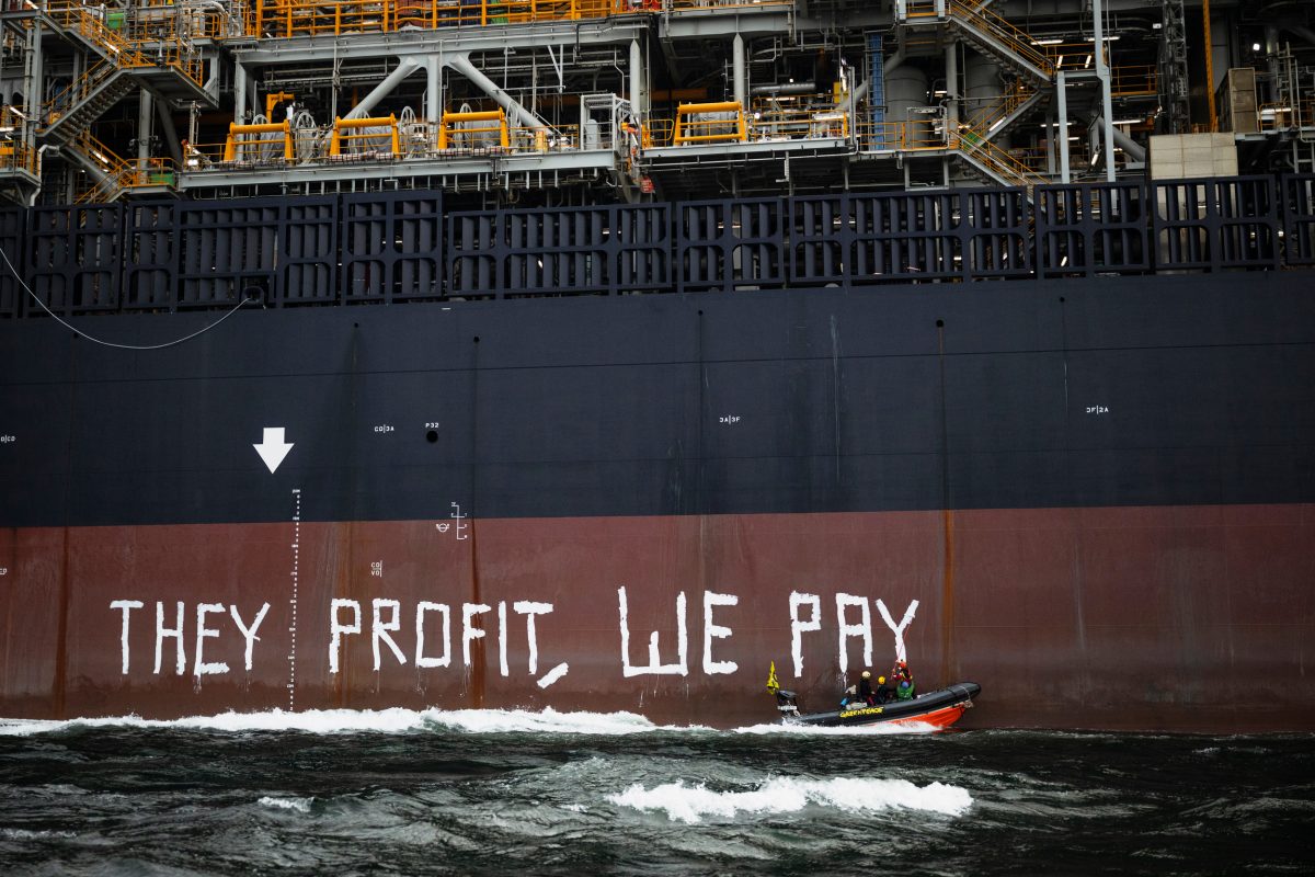 Greenpeace activists painting slogan on FPSO hull during Rosebank offshore oil protest