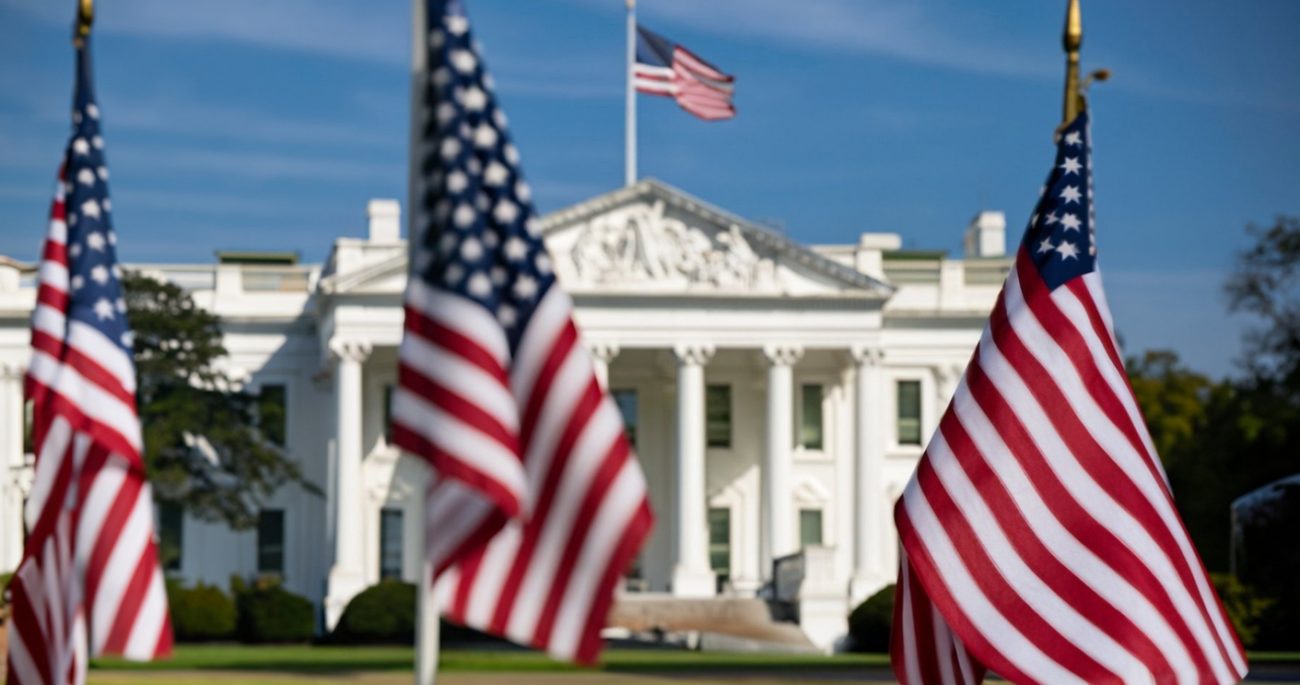 US flags and the White House in Washington linked to Jones Act waiver allowing foreign ships in domestic trade