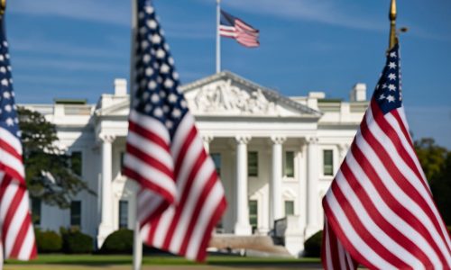 US flags and the White House in Washington linked to Jones Act waiver allowing foreign ships in domestic trade