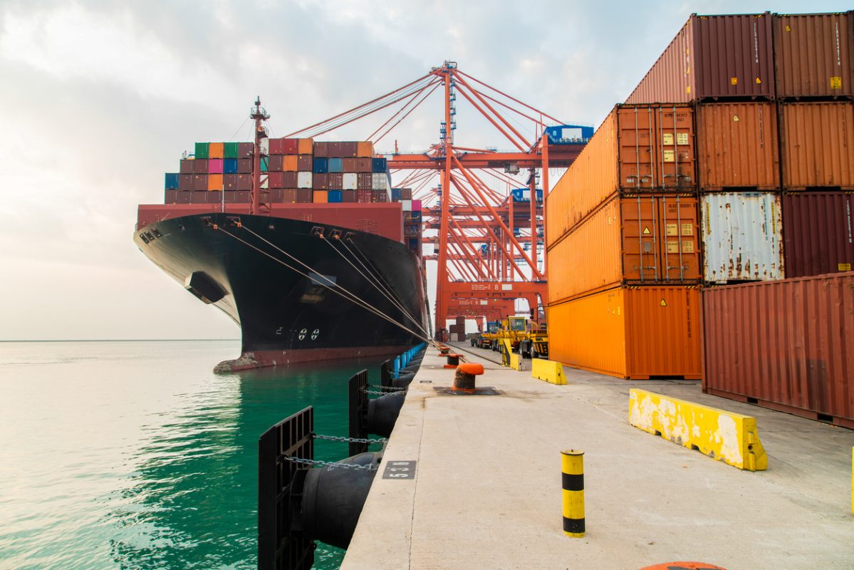 Container ship loading cargo at port terminal