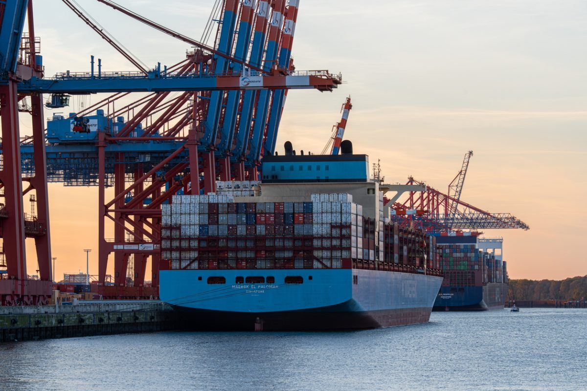 Container ship with stacked cargo containers docked at the Port of Hamburg container terminal.