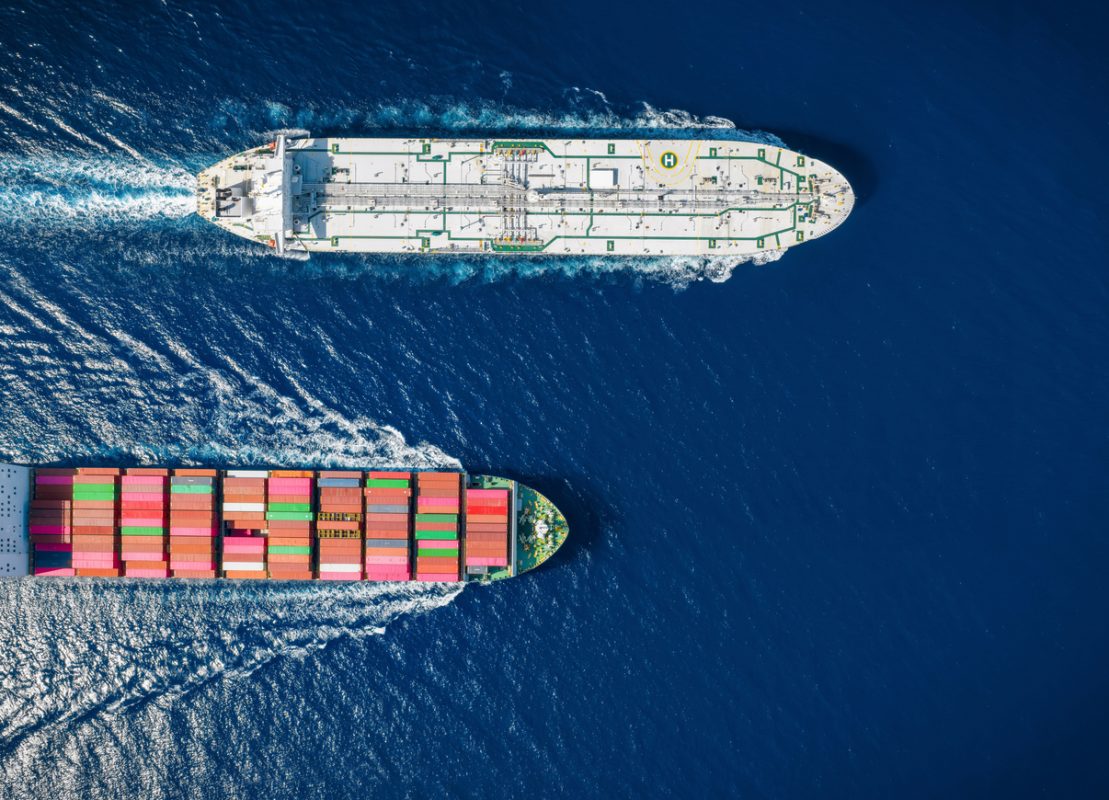 Container ship and crude oil tanker crossing at sea on international maritime shipping routes.