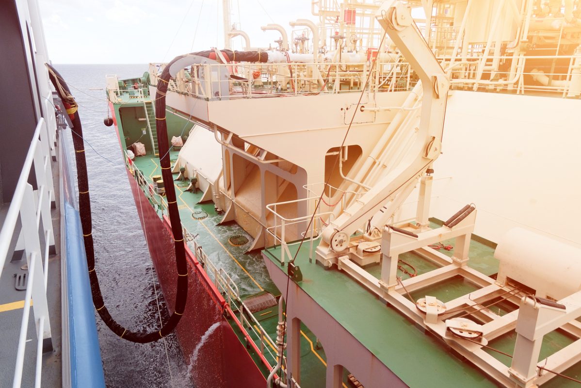 Ship to ship LNG bunkering transfer between tanker and LNG powered vessel at sea.