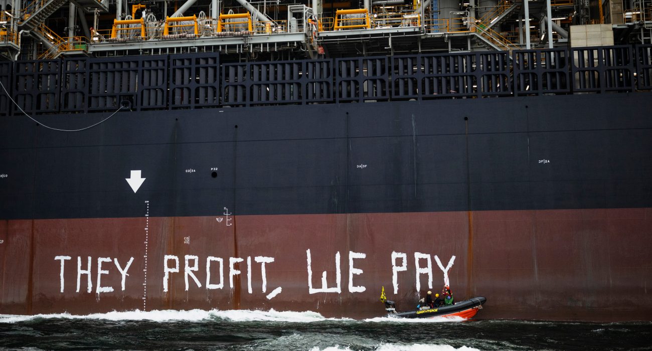 Greenpeace activists painting slogan on FPSO hull during Rosebank offshore oil protest