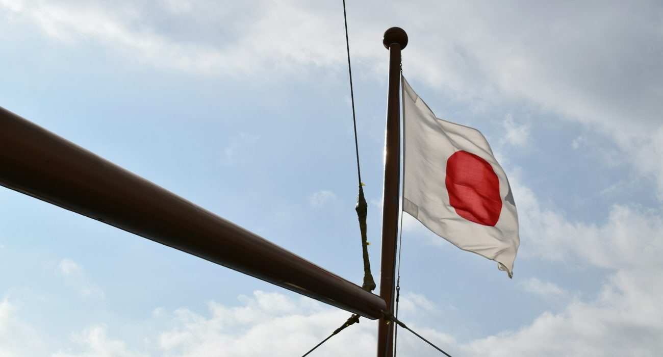 Illustrative flag at sea accompanying article on Japanese carriers halting Hormuz transits