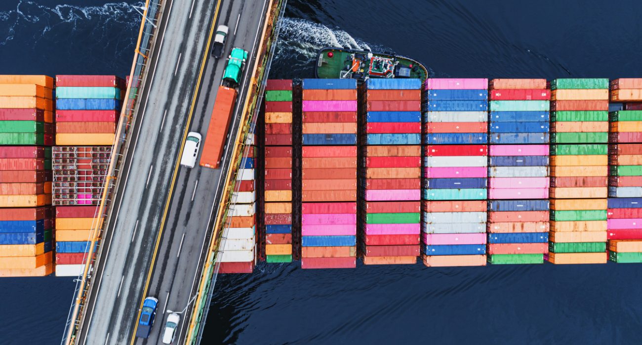 Container ship departing port carrying cargo on global maritime trade routes