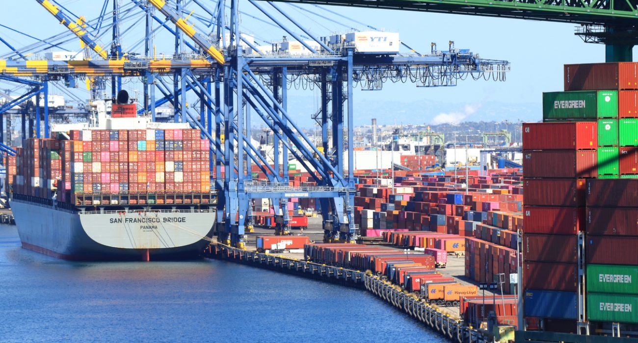 Busy container terminal at the Port of Los Angeles with cranes and containers.