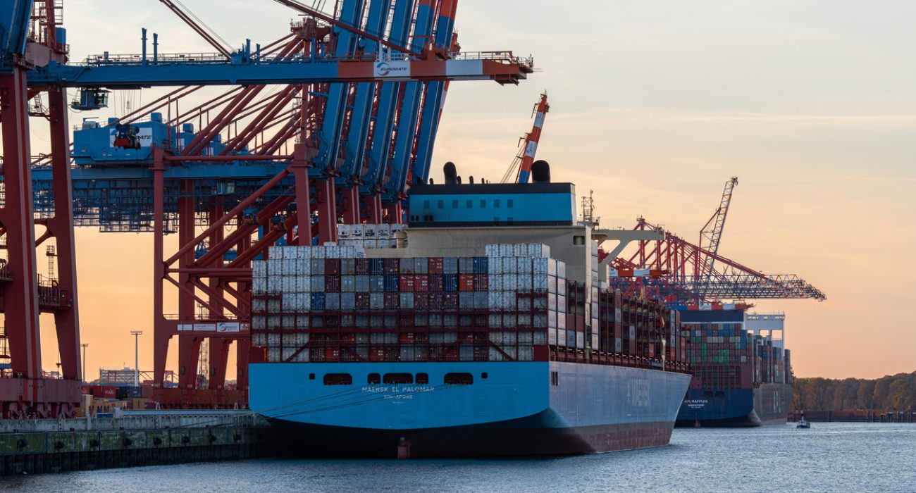 Container ship with stacked cargo containers docked at the Port of Hamburg container terminal.
