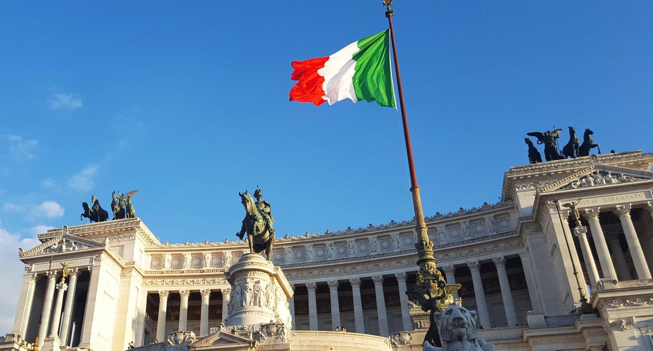 Italian flag above Rome representing Italy’s legislative action on emigrant boat policy